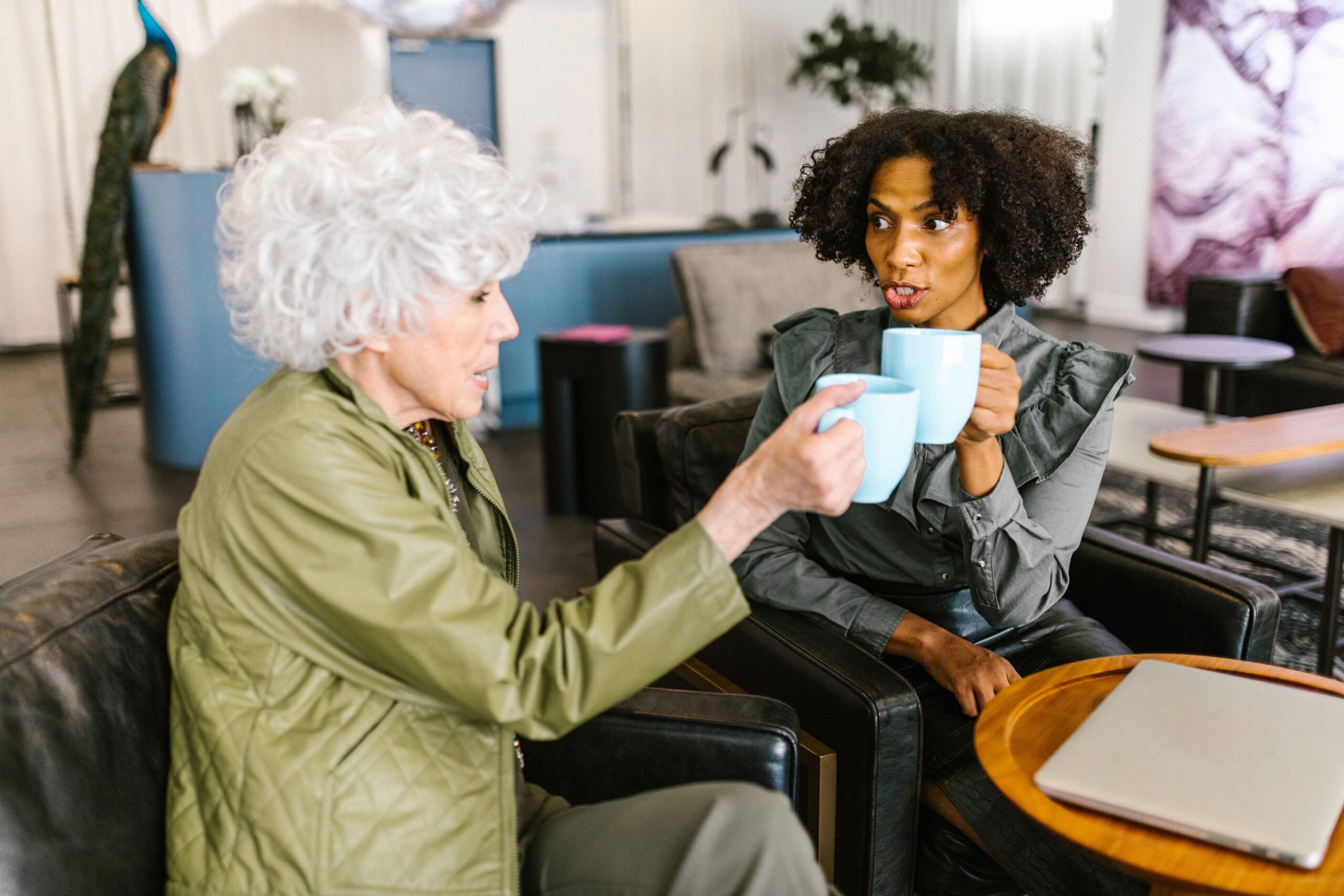 Older adult and companion enjoying a relaxed conversation over coffee